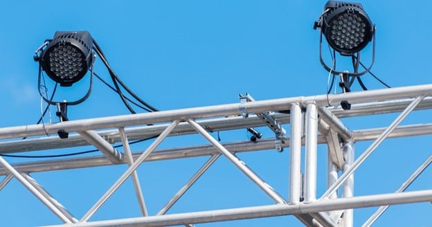 Close-up of aluminum box truss junction showing the connections, pins, and hardware that form the structural system.